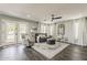 Bright living room with french doors, neutral decor and dark wood look floors at 3252 E Lexington Ave, Gilbert, AZ 85234