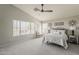 Spacious main bedroom with a ceiling fan, large windows, and neutral decor at 3252 E Lexington Ave, Gilbert, AZ 85234