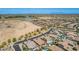 Aerial view showing houses, community pond, desert, and road in a scenic neighborhood at 3269 E Ironside Ln, Gilbert, AZ 85298