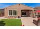 Expansive backyard featuring lush artificial turf, a covered patio, flower pots, and a brick planter at 3269 E Ironside Ln, Gilbert, AZ 85298