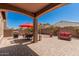 Inviting backyard with covered patio, pavers, seating, BBQ grill, and a well-maintained landscape with a red umbrella at 3269 E Ironside Ln, Gilbert, AZ 85298