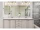 Bathroom featuring a double vanity with framed mirrors and a walk-in shower with gray tiling at 3269 E Ironside Ln, Gilbert, AZ 85298