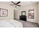 Neutral bedroom with a ceiling fan, dark dresser with a mirror, and natural light from a window at 3269 E Ironside Ln, Gilbert, AZ 85298