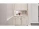Elegant hallway nook with custom cabinets, drawers, countertop, and stylish decor with a table lamp and flowers at 3269 E Ironside Ln, Gilbert, AZ 85298