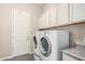 Spacious laundry room with a washer and dryer, ample cabinet space, and convenient access to the backyard at 3269 E Ironside Ln, Gilbert, AZ 85298