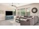 Bright living room featuring large windows, neutral tones, a ceiling fan and a comfortable sofa at 3269 E Ironside Ln, Gilbert, AZ 85298