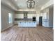 Spacious kitchen featuring white cabinets, a large center island, stainless steel appliances, and hardwood floors at 34889 N 3Rd St, Phoenix, AZ 85086