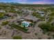 Aerial shot captures a custom desert backyard with sparkling pool, trampoline, and lush green landscaping at 3816 E El Sendero Rd, Cave Creek, AZ 85331