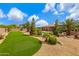 Landscaped backyard features lush green lawns, mature trees, desert plants, and cozy lounging next to the large pool at 3816 E El Sendero Rd, Cave Creek, AZ 85331