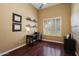 Well-lit home office with dark wood floors, floating shelves, and a comfortable workspace by the window at 3816 E El Sendero Rd, Cave Creek, AZ 85331