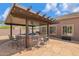 Beautiful outdoor kitchen with bar seating and stainless steel BBQ grill under a pergola at 3816 E El Sendero Rd, Cave Creek, AZ 85331