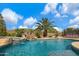 Inviting backyard pool featuring a waterfall, lush palm trees, and a clear blue sky backdrop at 3816 E El Sendero Rd, Cave Creek, AZ 85331