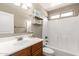 Bathroom features a wood vanity, a shower-tub combo, and decorative shelves at 3994 E Maplewood St, Gilbert, AZ 85297