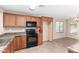 Bright kitchen boasts wood cabinetry, black appliances, tile flooring, and a breakfast nook at 3994 E Maplewood St, Gilbert, AZ 85297