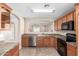 Cozy kitchen with warm wood cabinets, stainless steel appliances, tile backsplash, and a breakfast bar at 3994 E Maplewood St, Gilbert, AZ 85297