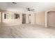 Spacious living room with neutral walls, a ceiling fan, and an open view into the kitchen at 3994 E Maplewood St, Gilbert, AZ 85297