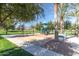 A playground area with swings and playset in a grassy, tree-lined park setting at 3994 E Maplewood St, Gilbert, AZ 85297
