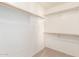 Walk-in closet with ample storage space, including hanging rods and shelving, and neutral carpet flooring at 3994 E Maplewood St, Gilbert, AZ 85297