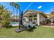 Beautiful backyard featuring well-manicured artificial turf, covered patio, and a glimpse of the refreshing private pool at 4061 W Tonopah Dr, Glendale, AZ 85308