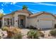 Charming one-story home exterior with a covered entryway, desert landscaping, and two car garage at 4061 W Tonopah Dr, Glendale, AZ 85308