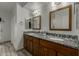 Bathroom with double sink vanity featuring granite countertop, wood cabinets, and modern fixtures at 4747 N 84Th Way, Scottsdale, AZ 85251