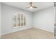 Empty bedroom features a ceiling fan, large window with shutters, and neutral decor at 4747 N 84Th Way, Scottsdale, AZ 85251