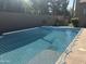 Backyard pool covered with a blue safety net and concrete patio surround at 4747 N 84Th Way, Scottsdale, AZ 85251