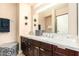 Well-lit bathroom featuring dark wood cabinets, double sinks, a large mirror, and modern light fixtures at 4808 N 24Th St # 527, Phoenix, AZ 85016