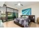 Bright bedroom featuring a sliding glass door, tile flooring, modern ceiling fan, and a large eye-catching piece of art at 4808 N 24Th St # 527, Phoenix, AZ 85016
