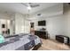 Comfortable bedroom featuring tile flooring, a dark dresser with a TV, and neutral paint throughout with a view into the bathroom at 4808 N 24Th St # 527, Phoenix, AZ 85016