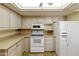 Bright kitchen featuring white appliances, neutral countertops, and ample cabinet space for storage at 562 S Palo Verde Way, Mesa, AZ 85208