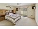 Spacious main bedroom featuring a large bed, sliding glass doors, and a ceiling fan at 562 S Palo Verde Way, Mesa, AZ 85208