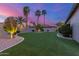 This backyard features green grass, manicured plants, trees, landscape lighting, and fencing at 5639 S Four Peaks Pl, Chandler, AZ 85249