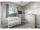 Bedroom with a white crib, gray walls, wood floors, and a view of the exterior at 5639 S Four Peaks Pl, Chandler, AZ 85249