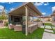 This outdoor living space has an outdoor kitchen, television, comfortable seating, and green turf at 5639 S Four Peaks Pl, Chandler, AZ 85249