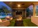 Outdoor living area featuring a fireplace, tv, seating, and a view of the pool at 5639 S Four Peaks Pl, Chandler, AZ 85249