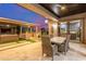 Covered patio with a dining table, outdoor kitchen, seating area, and lush landscaping at 5639 S Four Peaks Pl, Chandler, AZ 85249