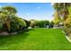 Large backyard with a playground, mature trees, and green grass at 5740 N Casa Blanca Dr, Paradise Valley, AZ 85253
