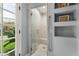 Stylish shower featuring seamless glass, a convenient grab bar, and a window offering a view of the lush outdoors at 5740 N Casa Blanca Dr, Paradise Valley, AZ 85253