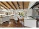 Open-concept kitchen and dining area featuring wood-beam ceilings, seating, and large windows with backyard views at 5740 N Casa Blanca Dr, Paradise Valley, AZ 85253
