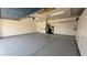 View of spacious garage with gray epoxy floors and installed shelving and storage at 63 W Los Arboles Dr, Tempe, AZ 85284