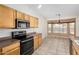 Kitchen with stainless steel appliances and wood cabinets adjacent to an eating nook with bay windows at 6372 S Callaway Dr, Chandler, AZ 85249