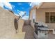 Narrow side yard with desert landscaping and a stainless steel gas grill at 6372 S Callaway Dr, Chandler, AZ 85249