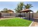 Lush backyard featuring synthetic grass, a built-in BBQ, and a shaded patio area at 7869 W Market St, Glendale, AZ 85303