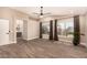 Bright bedroom featuring wood floors, ceiling fan, and view to an ensuite bathroom at 7869 W Market St, Glendale, AZ 85303