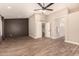 Large bedroom with wood floors, ceiling fan, dark accent wall, and two entrance doors at 7869 W Market St, Glendale, AZ 85303