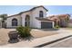 Charming two-story home with an arched entry, tile roof, desert landscaping, and a two car garage at 7869 W Market St, Glendale, AZ 85303