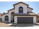 Charming two-story home with an arched entry, tile roof, desert landscaping, and a two car garage at 7869 W Market St, Glendale, AZ 85303