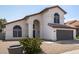 Charming two-story home with an arched entry, tile roof, desert landscaping, and a two car garage at 7869 W Market St, Glendale, AZ 85303