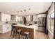Modern kitchen with white cabinets, stainless steel appliances, island seating, and wood floors at 7869 W Market St, Glendale, AZ 85303